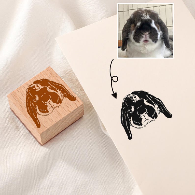May include: A wooden stamp with a brown and white rabbit illustration. The stamp is used to create a black and white rabbit illustration on paper.