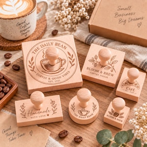 Puede incluir: Una colección de seis sellos de goma de madera clara con mangos redondeados. Los sellos presentan varios diseños relacionados con el café y textos que incluyen The Daily Bean, Bloom & Brew, Cafe y Handmade With Love sobre una superficie de madera.