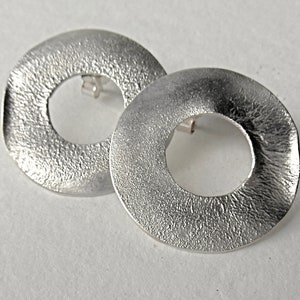 large round ear studs in silver with a subtle surface structure, an eye-catcher on the ear, simple and yet a statement image 3