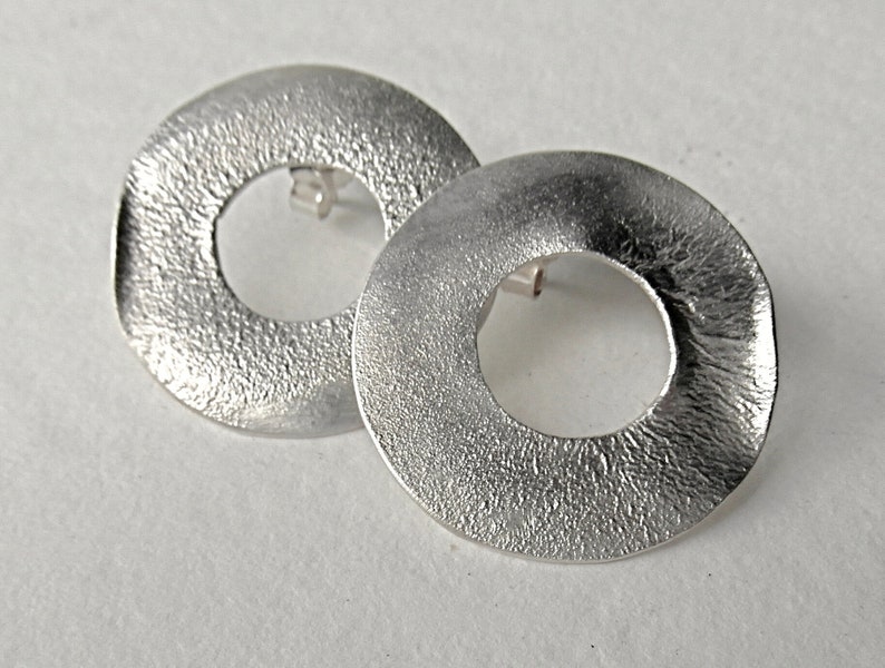 large round ear studs in silver with a subtle surface structure, an eye-catcher on the ear, simple and yet a statement image 3