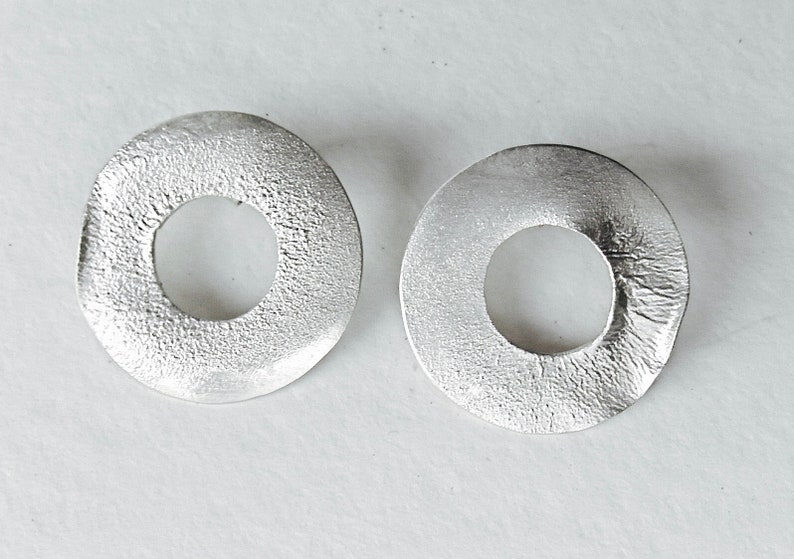 large round ear studs in silver with a subtle surface structure, an eye-catcher on the ear, simple and yet a statement image 2