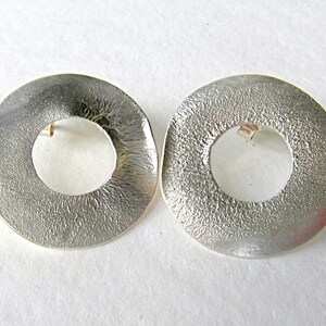 large round ear studs in silver with a subtle surface structure, an eye-catcher on the ear, simple and yet a statement image 4