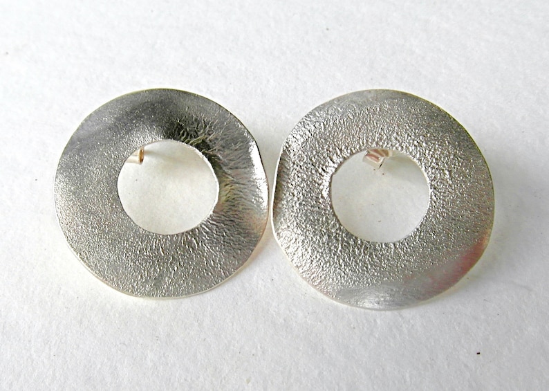 large round ear studs in silver with a subtle surface structure, an eye-catcher on the ear, simple and yet a statement image 4