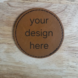 May include: A brown leather coaster with the text "your design here" printed on it.