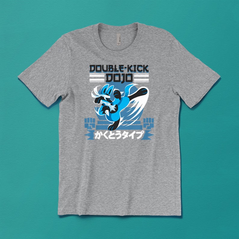 May include: A grey t-shirt featuring a blue cartoon character performing a double kick, with the text "DOUBLE-KICK DOJO" and Japanese text "かくとうタイプ" underneath.