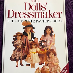 May include: The Dolls' Dressmaker book cover featuring a title in burgundy and images of antique dolls. The book cover includes the text "THE COMPLETE PATTERN BOOK" and "Over 120 designs with actual size patterns."