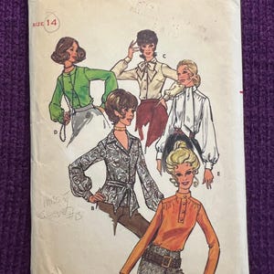 Könnte beinhalten: Vintage Butterick Schnittmuster, Größe 14, mit Illustrationen von Damenblusen und -oberteilen. Die Schnittmusterhülle enthält den Text "Butterick" und die Nummer "5734". Die Hülle ist leicht abgenutzt.