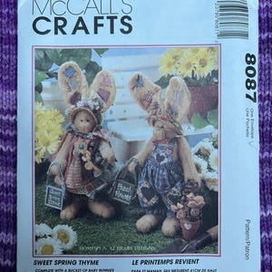 May include: McCall's Crafts pattern for Sweet Spring Thyme. The pattern includes instructions for making baby bunnies and clothes. The Mom and Pop bunny are 16 inches tall. The image shows two bunny dolls.