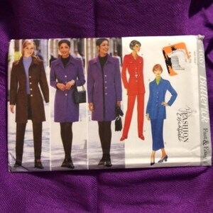 May include: A Butterick sewing pattern featuring images of women in coats and suits. The pattern includes a brown coat, purple coats, a red suit, and a blue suit. The pattern is labeled "Fashion Essentials."