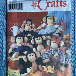 May include: Simplicity Crafts pattern number 7155 for making a set of five monkey rag dolls. The pattern includes instructions for making a monkey with overalls, a monkey with a dress, a monkey with a shirt, and two monkeys with no clothes. The pattern is for one size.
