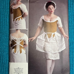 May include: Simplicity sewing pattern number 8579 size UK 12-18, R5, for a corset and skirt. The pattern shows a woman wearing a white skirt and a brown corset with a white lace trim. The pattern is designed and printed in the USA.