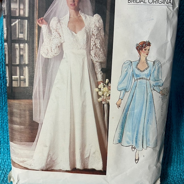 May include: A vintage Vogue Patterns bridal original sewing pattern featuring two wedding dresses. The first dress is a white gown with lace sleeves and a long veil. The second dress is a light blue gown with puffed sleeves. The pattern is labeled "Vogue Patterns Bridal Original".