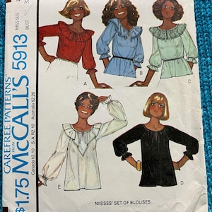 May include: A vintage McCall's 5913 sewing pattern for misses' blouses. The pattern shows illustrations of blouses in red, blue, and green, with different sleeve and neckline designs. The text on the pattern includes "CAREFREE PATTERNS" and "MISSES' SET OF BLOUSES".