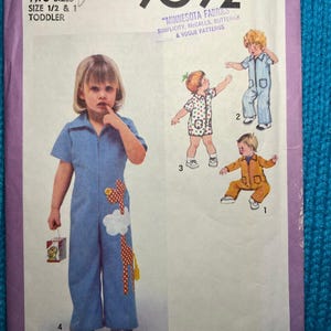 May include: Simplicity sewing pattern number 9092 for a toddler jumpsuit with applique designs. The pattern includes two sizes, 1/2 and 1. The pattern cover features a child wearing a blue jumpsuit with a giraffe applique. The pattern is for use with Minnesota Fabrics, Simplicity, McCall's, Butterick, and Vogue patterns.