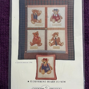 May include: A package featuring a sewing pattern titled "Old Bears." The pattern includes four different bear designs, each with a unique outfit and name: Buster, Sweetie, Edgar, and Gus. A smaller image shows a bear named Daisy. The text reads "4 Different Bears to Sew."