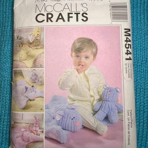 May include: A McCall's Crafts sewing pattern envelope featuring a baby with plush bunny toys. The envelope has the text "Made these bunnies 2006" and "MCCALL'S CRAFTS". The pattern includes instructions for making various bunny-themed items.