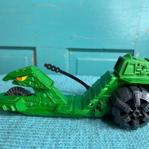 May include: A white ceramic mug with a black handle and the text "But First, Coffee" in a black, bold font. The mug is on a white surface.