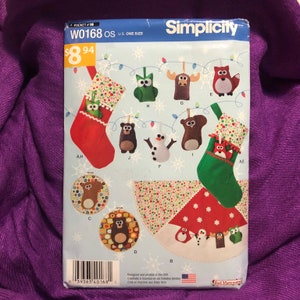 Könnte beinhalten: Simplicity Nähmuster W0168 OS zum Nähen von Weihnachtsornamenten. Das Muster enthält Anleitungen zum Nähen einer Vielzahl von Ornamenten, darunter Eulen, Elche, Füchse, Bären, Schneemänner und Pinguine. Das Muster wurde in den USA entworfen und gedruckt.