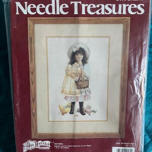 Könnte beinhalten: Versiegeltes Kreuzstich-Set mit dem Titel "Needle Treasures", das ein gerahmtes Bild eines Mädchens mit einem Teddybär und einem Blumenkorb zeigt. Das Set enthält Garn, Stickgarn, Nadeln und Anleitungen. Die Bildgröße beträgt 25,4 cm x 35,6 cm.