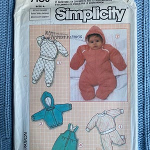 May include: Simplicity sewing pattern number 7108 for a baby's snowsuit, jacket, and overalls. The pattern includes instructions for making a quilted snowsuit, a blue jacket, and green overalls. The pattern is for sizes A.
