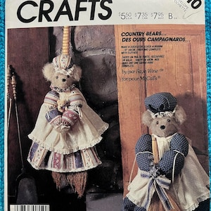 Puede incluir: Patrón de McCall's Crafts para topes de puerta y fundas de escoba Country Bears. El patrón presenta dos osos de peluche vestidos con ropa de estilo campestre, sosteniendo una escoba. El patrón incluye instrucciones.