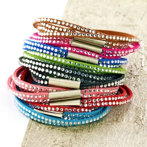 May include: A stack of colorful leather bracelets with crystal embellishments. Each bracelet has a silver magnetic clasp.