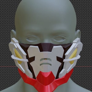 May include: A white, red, and gold face mask with geometric designs. The mask has a black center section with a small, round, orange light.