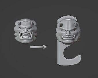 May include: A 3D printed wall hook with a detailed, stylized, gray, oni mask design. The hook is shaped like a 'C' and has a ring on the side.