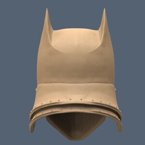 May include: A brown helmet with pointed ears and a textured surface. The helmet has a flap that covers the face and is secured with rivets.