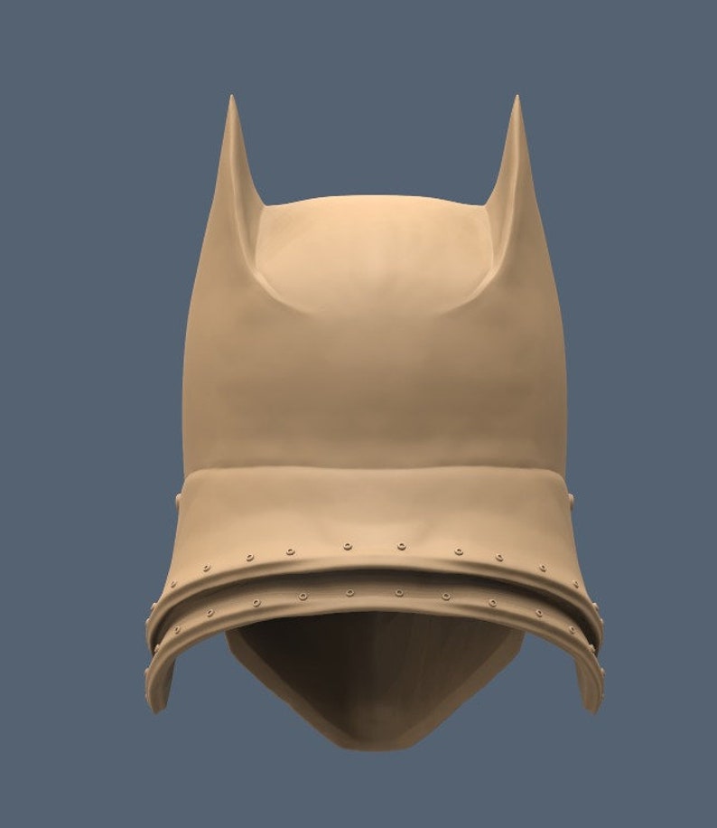 May include: A brown helmet with pointed ears and a textured surface. The helmet has a flap that covers the face and is secured with rivets.