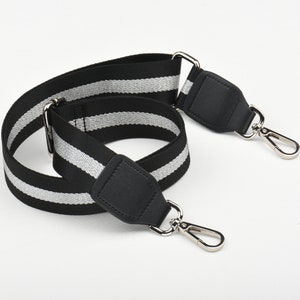 May include: Black and silver striped adjustable strap with black leather accents and silver swivel clasps.