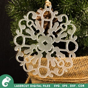 May include: A white snowflake ornament with a delicate, intricate design. The ornament is made of a thin, translucent material and has a slightly frosted appearance.