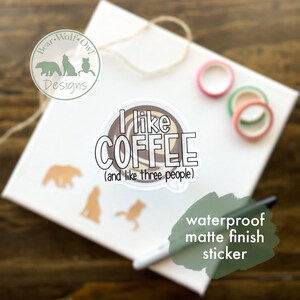 May include: A white sticker with a brown coffee cup illustration and the text "I like COFFEE (and like three people)". The sticker has a waterproof matte finish.