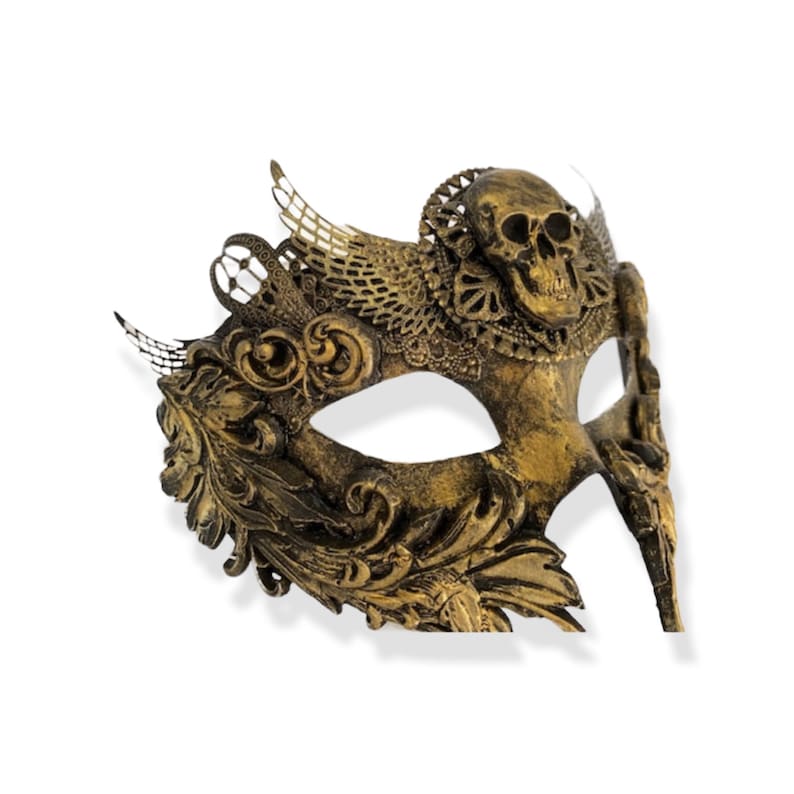 Op de afbeelding: Een goudkleurig masker met een schedelontwerp. Het masker heeft sierlijke details, waaronder bloem- en vleugelachtige accenten. Het masker is gemaakt van een metallic materiaal en is ontworpen om de ogen en neus te bedekken.