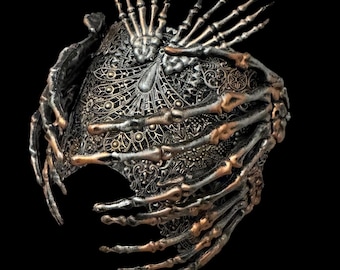 May include: A decorative headpiece featuring intricate metallic filigree patterns in silver and bronze tones. The structure is adorned with multiple sculpted skeletal hand motifs that wrap around the sides and extend upward from the top.