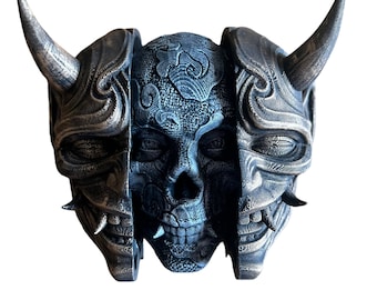May include: A black and gold skull mask with a detailed design. The mask is split in half, revealing a skull with intricate patterns.