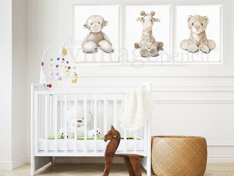 May include: A white crib with a white stuffed animal inside. There are three framed prints on the wall above the crib. The prints feature a monkey, a giraffe, and a tiger. The prints are all in shades of brown and white.