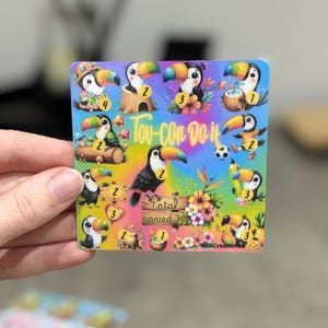 May include: A square sticker with cartoon toucans, each with a brightly coloured beak. The text "Tou-Can Do It" is in a rainbow font. The words "Total saved 30" are below a toucan, with floral accents.