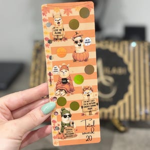 May include: A rectangular orange and white striped bookmark featuring five cartoon llamas with autumn-themed accessories and text including "LEAF ME ALONE," "OH MY GOURD!," "NOT TODAY PEOPLE," "NOPE," "I'M NOT LAZY," and "PUMPKINS, COFFEE & QUESTIONABLE DECISIONS."
