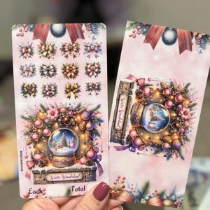 May include: Two pink Christmas-themed cards. One card features various bow designs. The other card displays a snow globe with a winter scene, surrounded by ornaments and the text "Winter Wonderland".