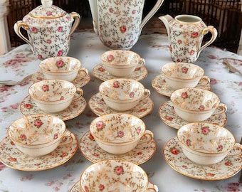 Peut inclure: Un service à thé vintage avec un motif floral. L'ensemble comprend une théière, un pot à crème, un sucrier et six tasses et soucoupes à thé. Les tasses et les soucoupes ont une bordure dorée et un motif floral délicat.