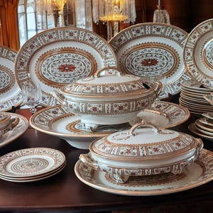 Puede incluir: Un juego de vajilla de porcelana antigua con ribetes dorados y intrincados diseños florales. El juego incluye platos, tazones y platos para servir.