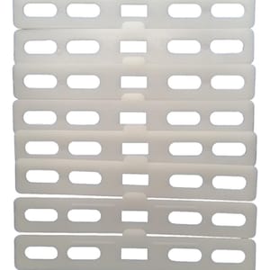 May include: Ten white plastic strips with multiple oval-shaped holes. The strips are stacked on top of each other.
