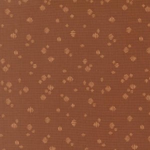 Puede incluir: Una tela de color marrón óxido sólido con un patrón repetitivo de pequeños motivos circulares de color beige claro. Cada motivo está compuesto por varias líneas paralelas horizontales finas, creando un aspecto texturizado y punteado.