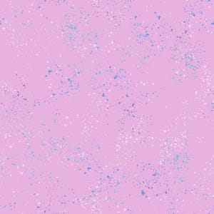 Puede incluir: Una tela o superficie de color rosa claro con un patrón repetitivo de pequeñas salpicaduras de pintura irregulares en tonos blanco, turquesa brillante y azul profundo, creando una apariencia texturizada y moteada sobre el fondo plano.