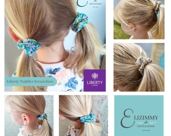 May include: A set of small fabric hair scrunchies featuring a multi-colored floral pattern on a light background. The scrunchies are shown in various hairstyles. The image includes the text Liberty London and Lizimmy Gifts & Home Est. 2012.