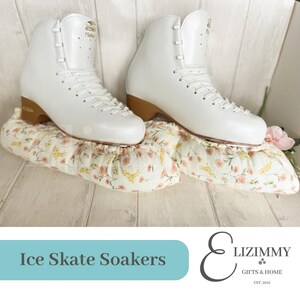 May include: White ice skates with brown soles are placed on top of floral patterned fabric soakers. The soakers are white with pink and yellow flowers. The text "Ice Skate Soakers" is on a teal background below the image. The text "Lizimmy Gifts & Home Est. 2012" is on a white background below the text "Ice Skate Soakers".