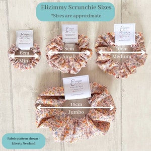 May include: Four scrunchies in different sizes, with a floral print. The scrunchies are labeled with their size in centimeters: 6cm Mini, 8cm Small, 10cm Medium, and 15cm Jumbo. The fabric pattern is Liberty Newland.