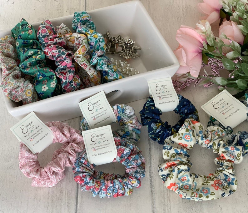 May include: A set of 10 mini scrunchies in various floral patterns. The scrunchies are made of soft fabric and are perfect for adding a touch of style to any hairstyle. The scrunchies are packaged in a clear plastic bag with a white label that reads "Lizzyman Mini Scrunchie Set".