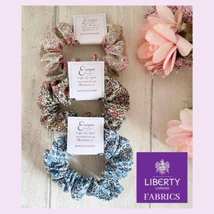Puede incluir: Tres scrunchies con estampado floral, cada uno con una etiqueta blanca que dice "Lizimmy" y "Medium Scrunchie". Los scrunchies están hechos con telas Liberty.